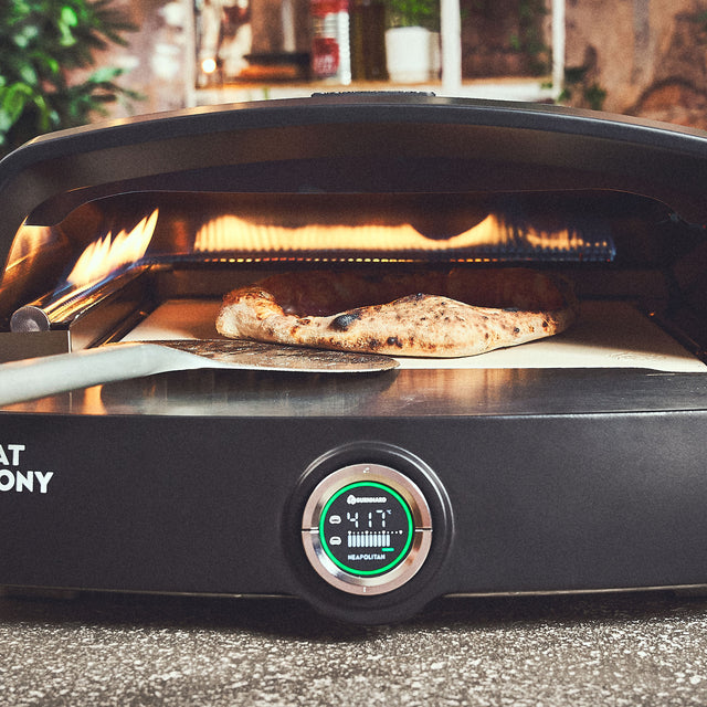 Pizza wordt in de oven gedraaid met een pizzadraaier