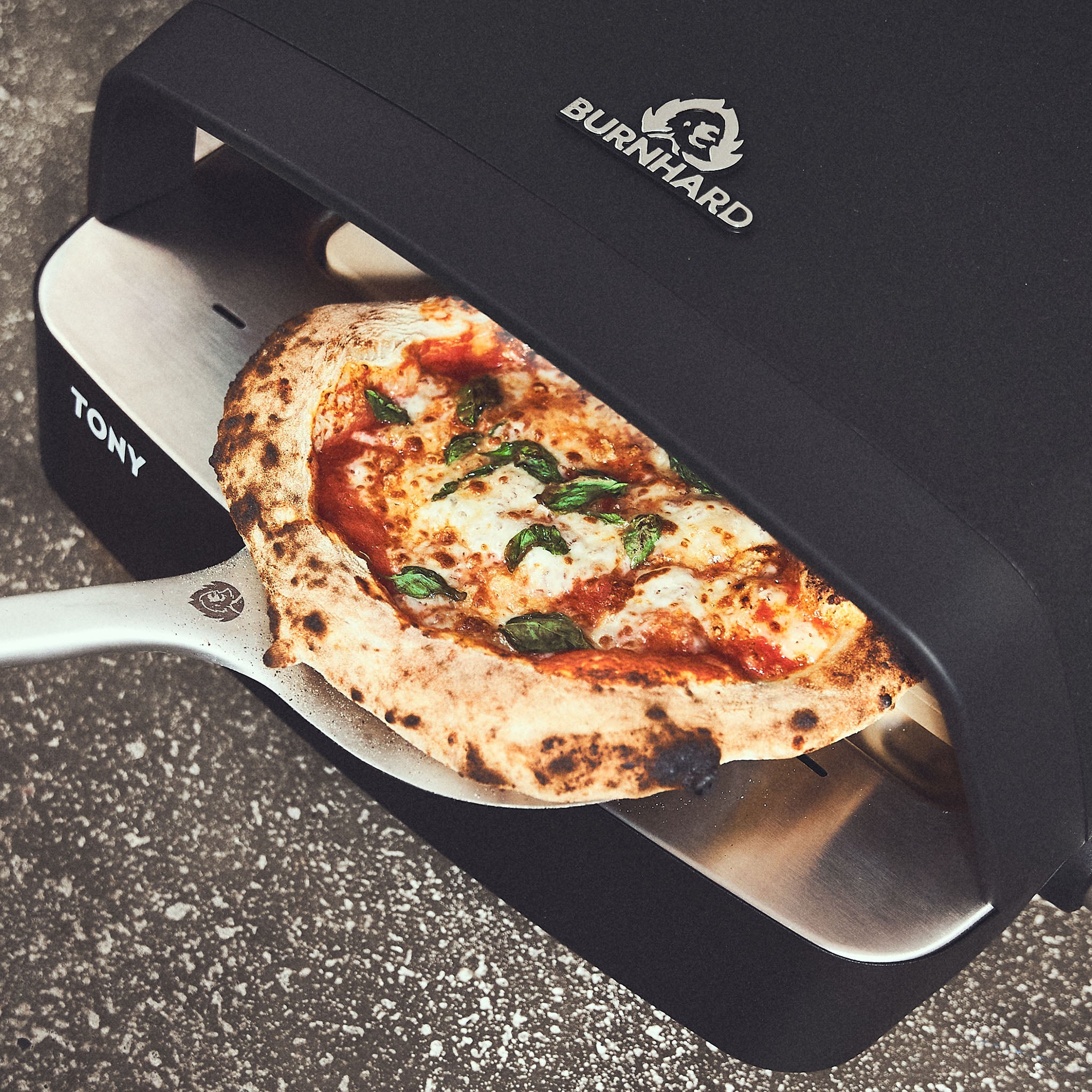 Afgewerkte pizza wordt uit de pizzaoven gehaald + 946535